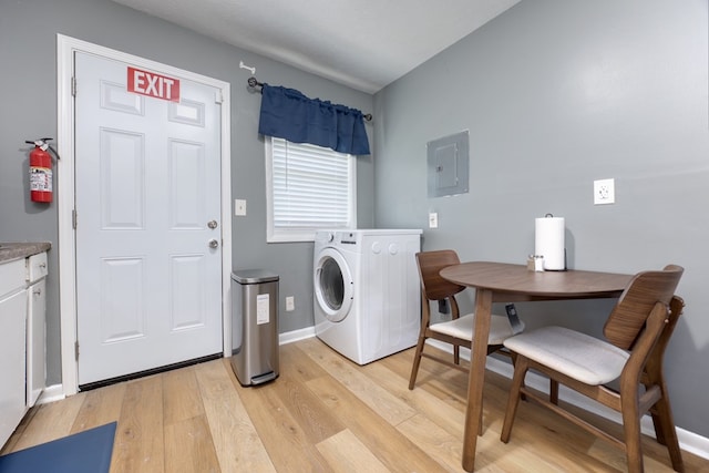 clothes washing area featuring washer / dryer, light hardwood / wood-style flooring, and electric panel