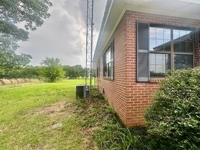 869 S County Road 0079, Eufaula, AL 36027 - view of property exterior with brick siding and a yard