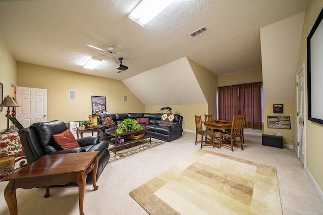 living room featuring ceiling fan, light colored carpet, lofted ceiling, and a textured ceiling