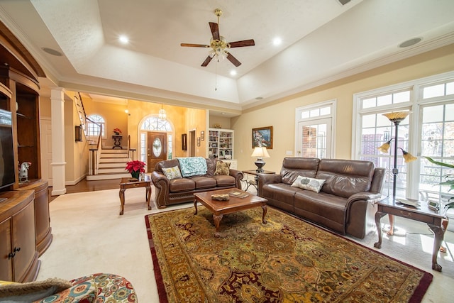 living room with ceiling fan, a healthy amount of sunlight, ornate columns, and a tray ceiling