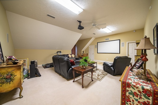 carpeted home theater room featuring lofted ceiling, ceiling fan, and a textured ceiling