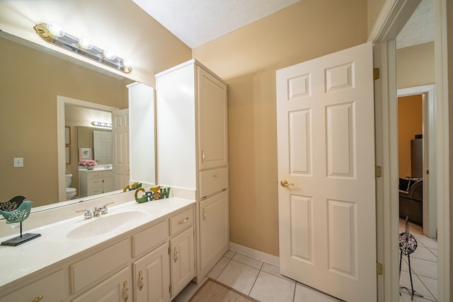 bathroom featuring tile patterned floors, vanity, a textured ceiling, and toilet