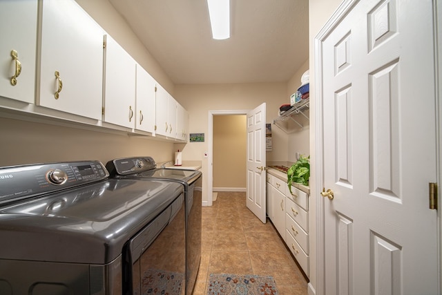 clothes washing area featuring cabinets and washing machine and dryer