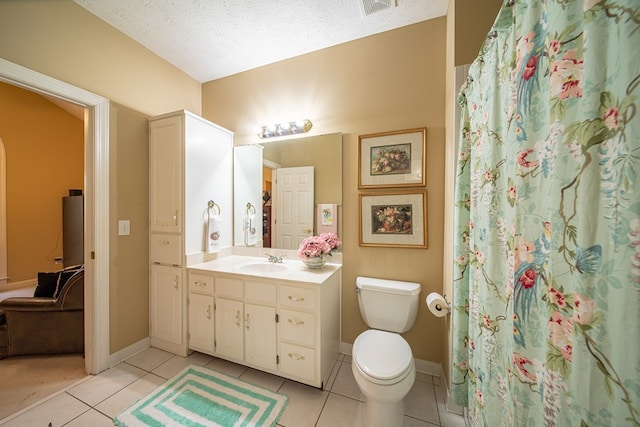 bathroom featuring tile patterned flooring, vanity, a textured ceiling, and toilet