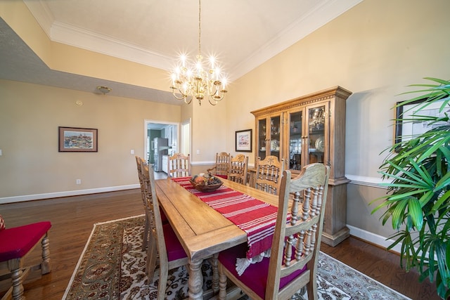 dining area with crown molding, dark wood-type flooring, and a chandelier