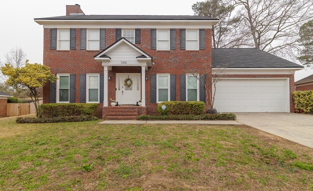 colonial house featuring a garage and a front lawn