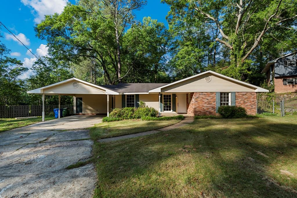 ranch-style home with fence, driveway, and a front yard