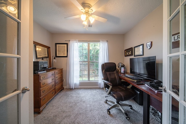 carpeted home office with french doors, a textured ceiling, and ceiling fan