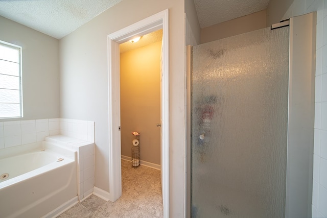 bathroom featuring tile patterned floors, separate shower and tub, and a textured ceiling