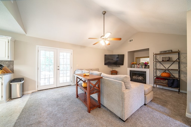 living room featuring light carpet, french doors, ceiling fan, and vaulted ceiling