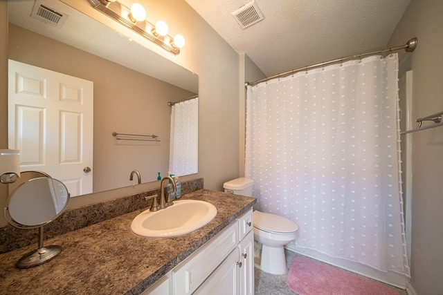 bathroom with vanity, curtained shower, toilet, and a textured ceiling