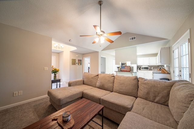 carpeted living room featuring a textured ceiling, vaulted ceiling, and ceiling fan