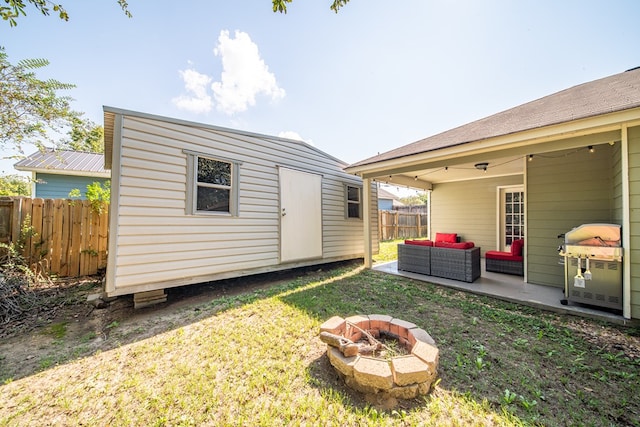 view of yard featuring a patio area, an outbuilding, and an outdoor living space with a fire pit