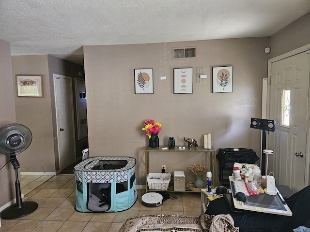interior space with a textured ceiling, visible vents, and baseboards