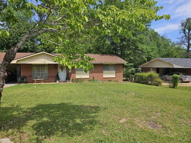 single story home featuring a front lawn, brick siding, and a carport