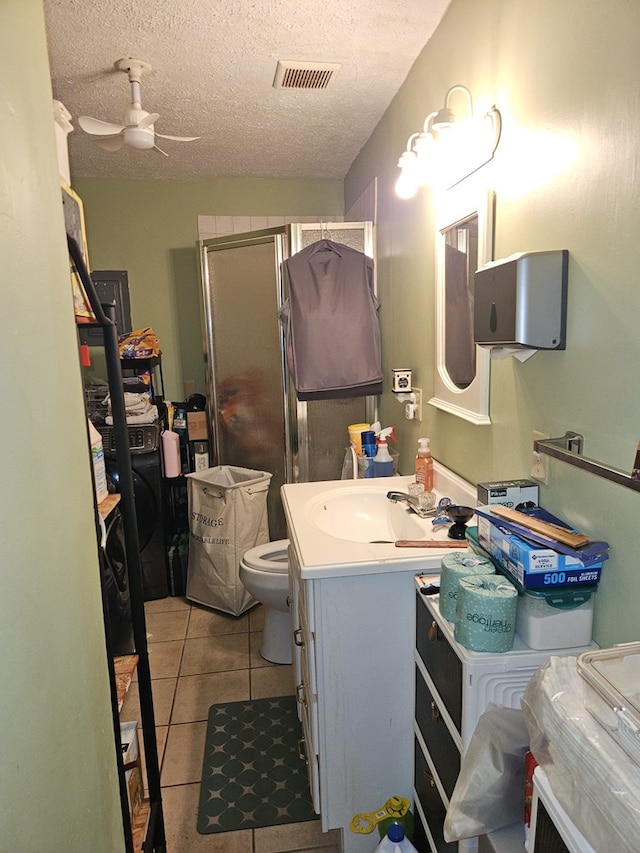 full bathroom featuring a shower stall, visible vents, a ceiling fan, vanity, and a textured ceiling