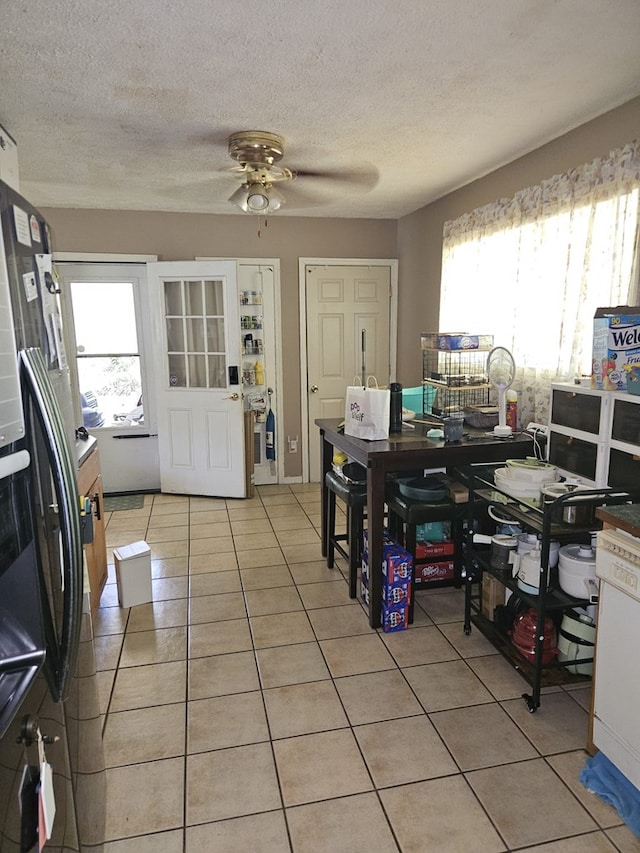 dining area featuring ceiling fan, a textured ceiling, and light tile patterned floors