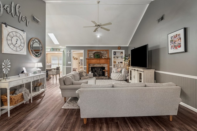 living area with dark wood-style floors, visible vents, wainscoting, and a fireplace