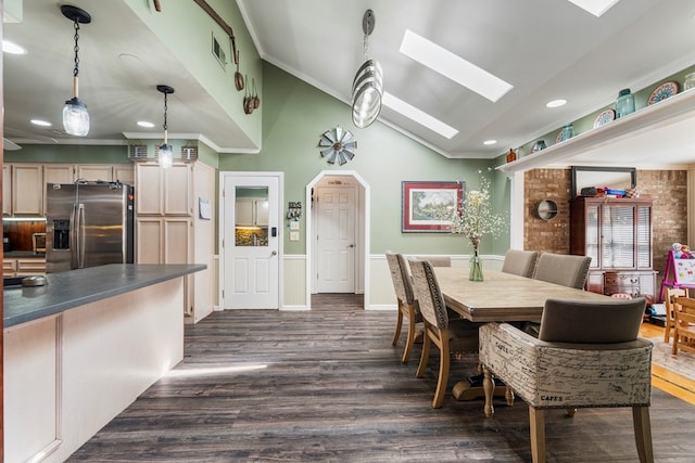 dining space featuring lofted ceiling with skylight, dark wood finished floors, recessed lighting, arched walkways, and crown molding