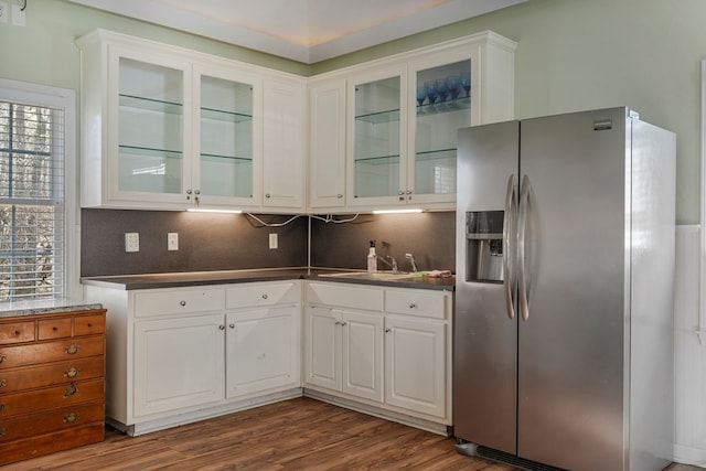 kitchen featuring a sink, dark countertops, white cabinetry, stainless steel fridge with ice dispenser, and dark wood-style flooring