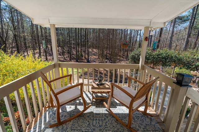 wooden deck with a wooded view