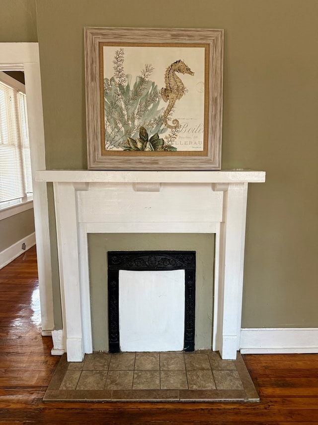 details with hardwood / wood-style floors and a tile fireplace