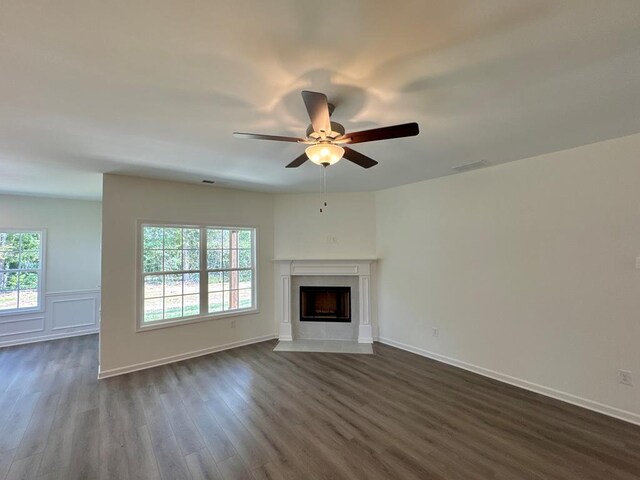 unfurnished living room with ceiling fan and dark wood-type flooring