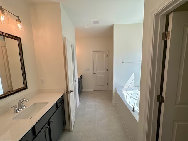 bathroom featuring tile patterned flooring, vanity, and a tub to relax in