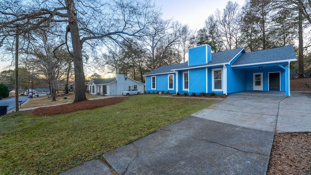 view of front of home with a carport and a front lawn