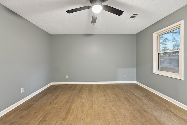 unfurnished room featuring ceiling fan, wood-type flooring, and a textured ceiling