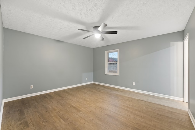 empty room featuring ceiling fan, wood-type flooring, and a textured ceiling