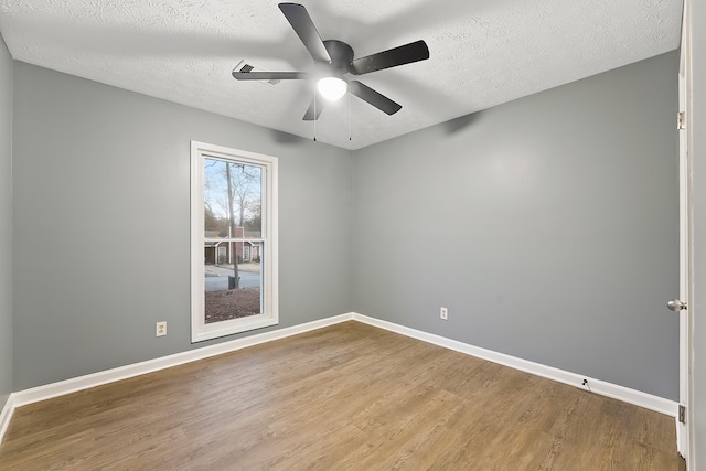 spare room with ceiling fan, wood-type flooring, and a textured ceiling