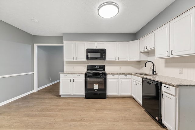 kitchen with black appliances, light wood-type flooring, white cabinetry, and sink