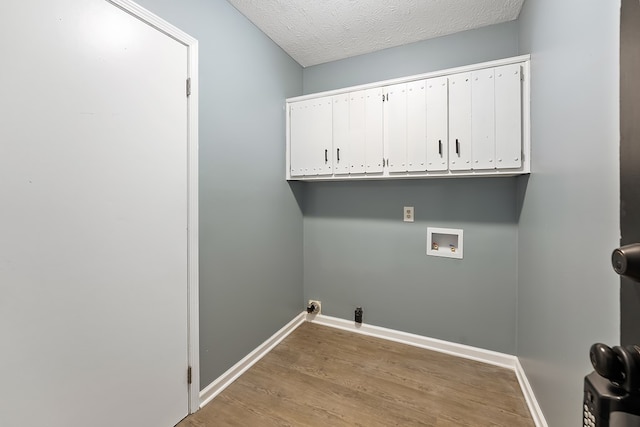 washroom featuring hookup for a washing machine, cabinets, a textured ceiling, and hardwood / wood-style flooring