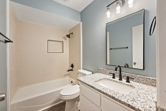 full bathroom featuring vanity, a textured ceiling, hardwood / wood-style flooring, toilet, and tiled shower / bath