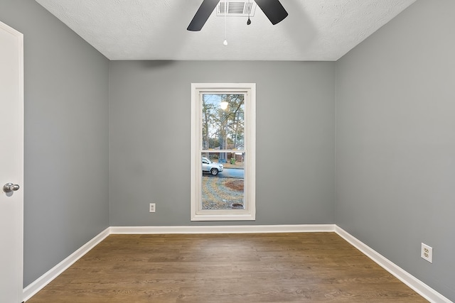 spare room with hardwood / wood-style floors, ceiling fan, and a textured ceiling