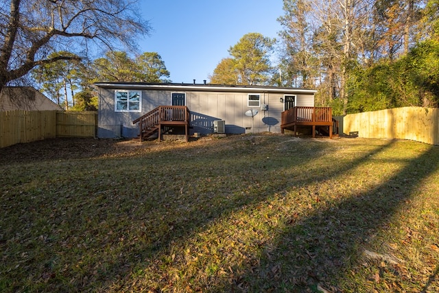 back of house with a yard, a deck, and central air condition unit