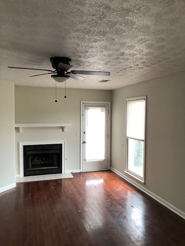 unfurnished living room featuring a textured ceiling, ceiling fan, and dark hardwood / wood-style floors