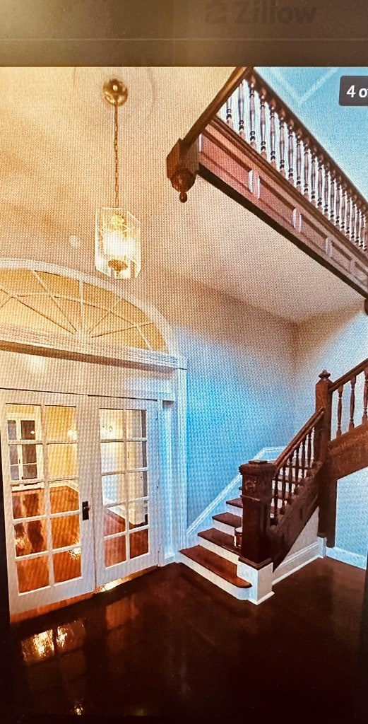 stairs featuring a high ceiling and a notable chandelier