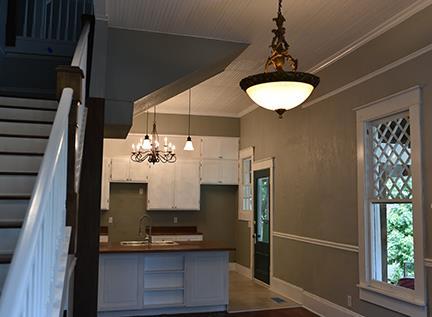 kitchen featuring crown molding, sink, pendant lighting, an inviting chandelier, and white cabinetry