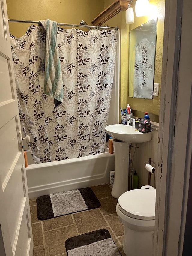 full bathroom with sink, shower / bath combo, and toilet