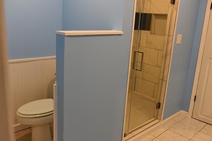 bathroom featuring tile patterned flooring, toilet, and a shower with door