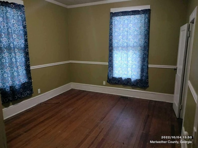 spare room with hardwood / wood-style floors and crown molding