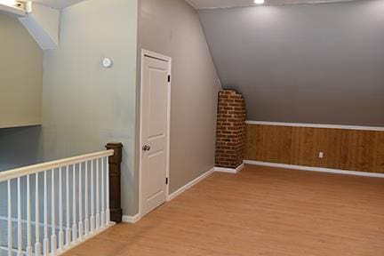 bonus room with lofted ceiling and light wood-type flooring