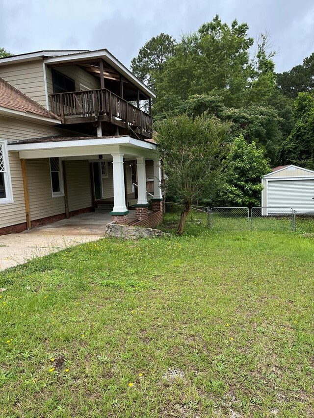 exterior space featuring a lawn and a balcony