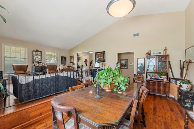 dining space featuring dark hardwood / wood-style flooring and high vaulted ceiling