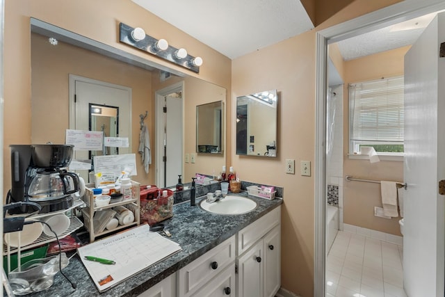 bathroom featuring tile patterned flooring, vanity, a textured ceiling, and bathing tub / shower combination