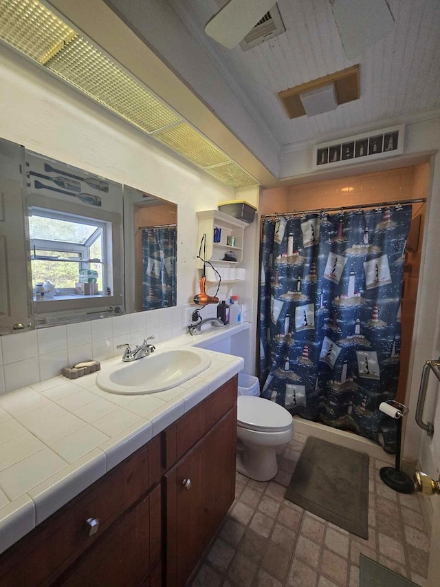 bathroom with curtained shower, vanity, toilet, and backsplash