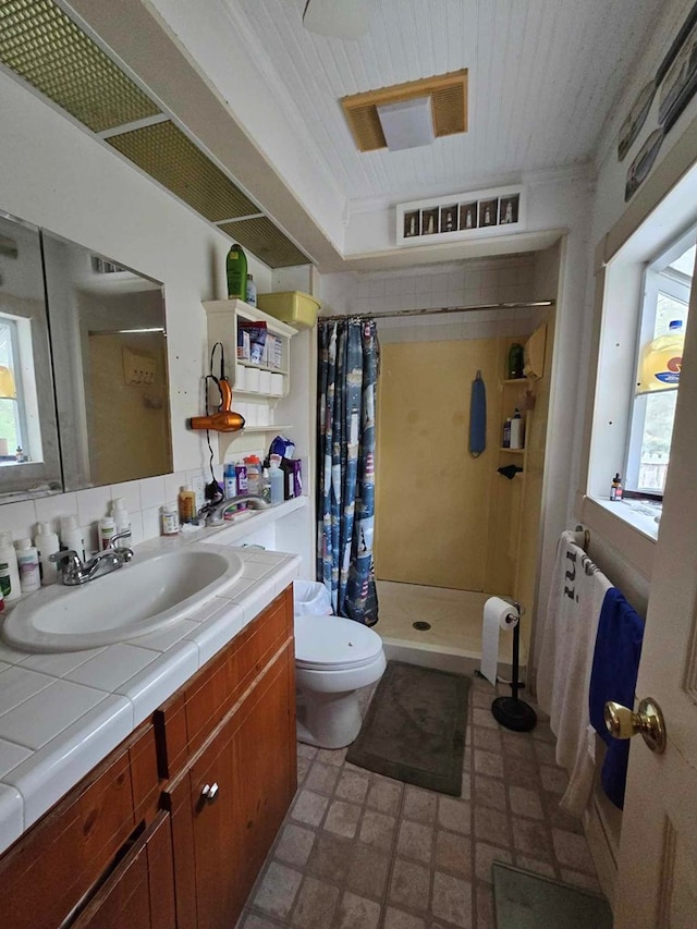 bathroom featuring vanity, toilet, and walk in shower