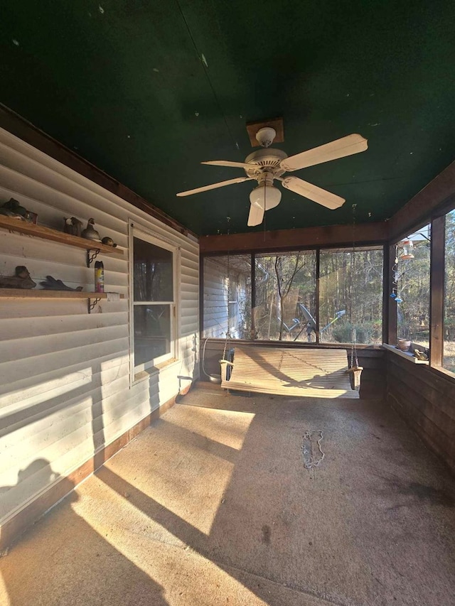 unfurnished sunroom featuring ceiling fan